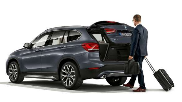 BMW X1, automatic tailgate operation. BMW X1, side view standing with open tailgate.