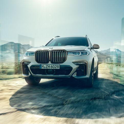BMW X7 M50d, low-angle-shot BMW X7 M50d: oblique low-angle-shot of driving, white BMW X7