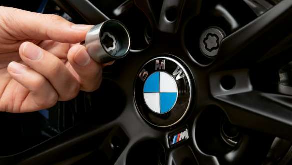BMW wheel bolt locking system Hand holding BMW wheel bolt locking system in front of a BMW wheel