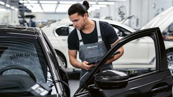 BMW Value Service vehicle check BMW Value Service workshop employee looks inside the vehicle