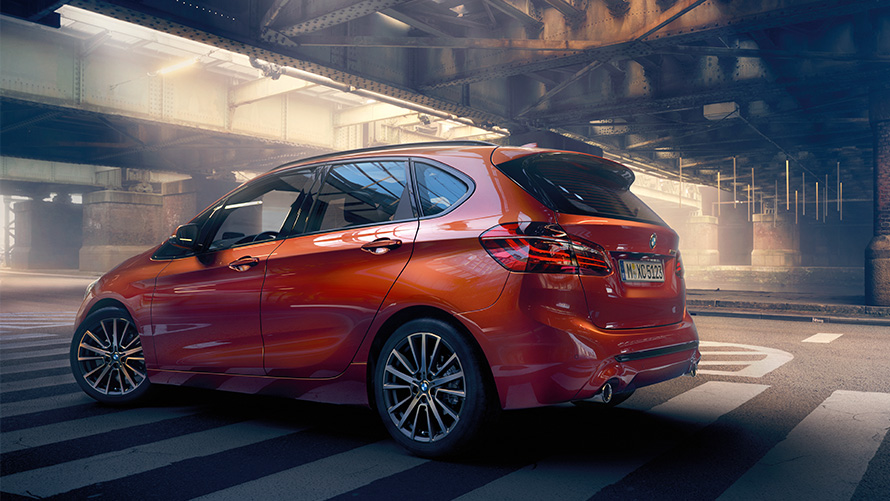Side view BMW 2 Series Active Tourer BMW 2 Series Active Tourer F45 Sunset Orange metallic side view standing in hall