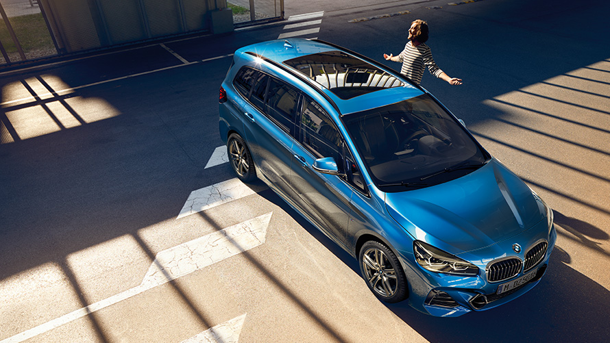 BMW 2 Series Gran Tourer with family Family standing next to BMW 2 Series Gran Tourer F46 2018 Estoril Blue metallic