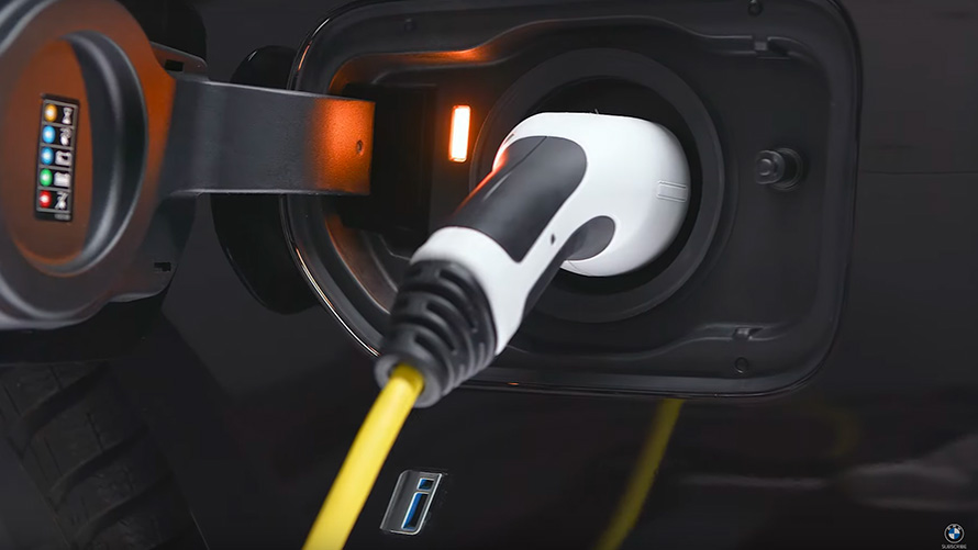 BMW plug-in hybrid connected with charging cable  BMW X5 G05 BMW plug-in hybrid connected with charging cable close-up