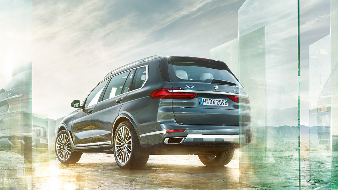 BMW X7 Comfort and Driving Dynamics BMW X7 in the three-quarter rear view in front of abstract background