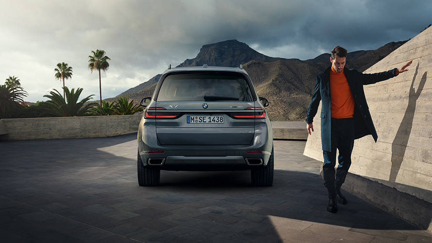 BMW X7 G07 LCI Rear View Sparkling Copper Grey metallic  BMW X7 G07 LCI Rear View with model right Sparkling Copper Grey metallic