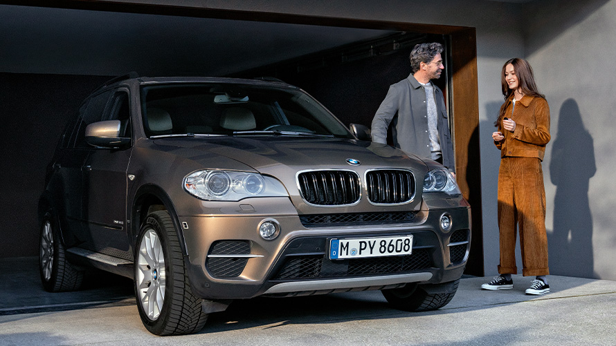 BMW standing in front of garage with models BMW Value Service BMW standing in front of garage with models